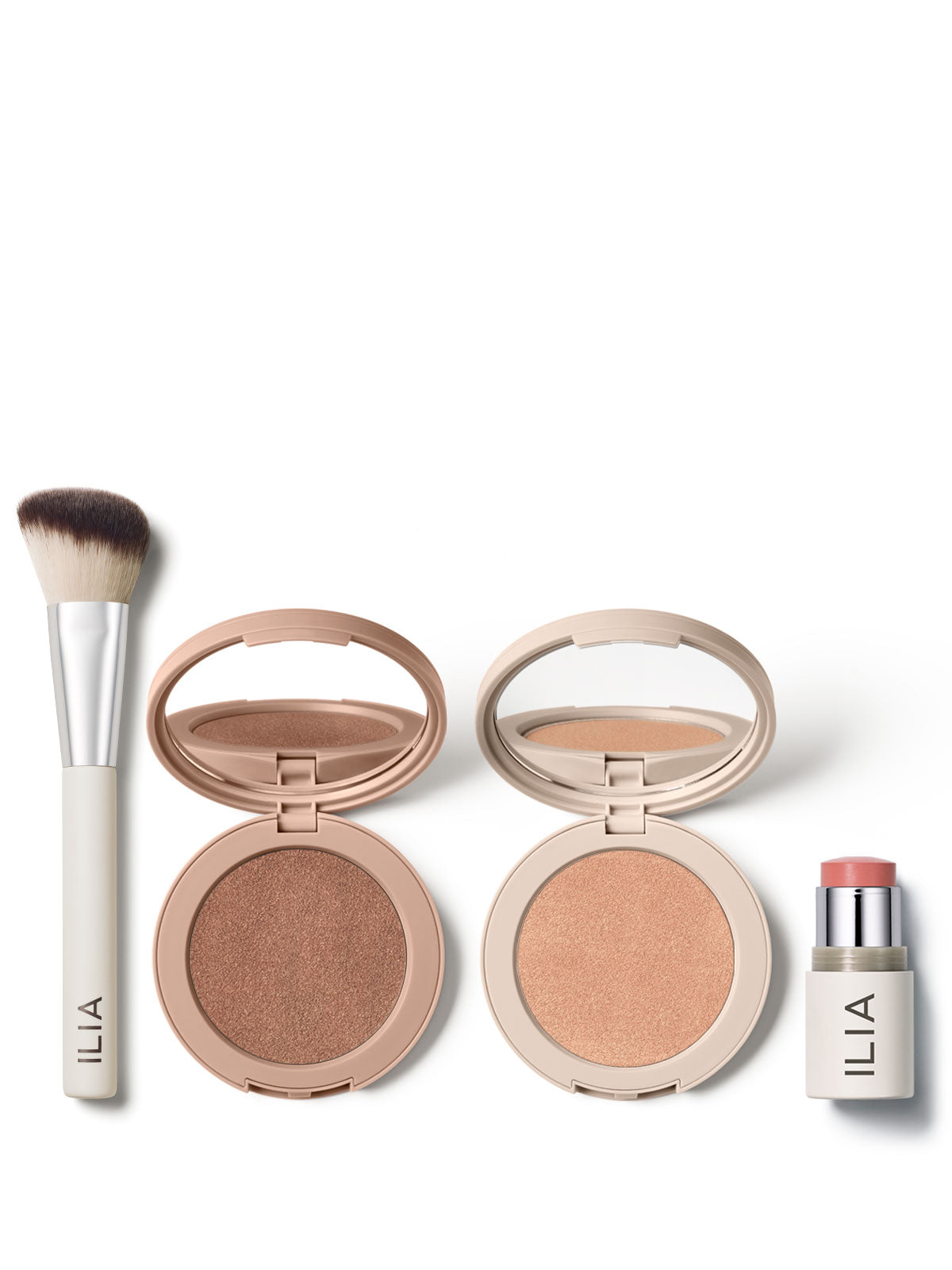 ILIA makeup essentials, featuring a sculpting brush, bronzer, highlighter, and blush stick, displayed on a white background.